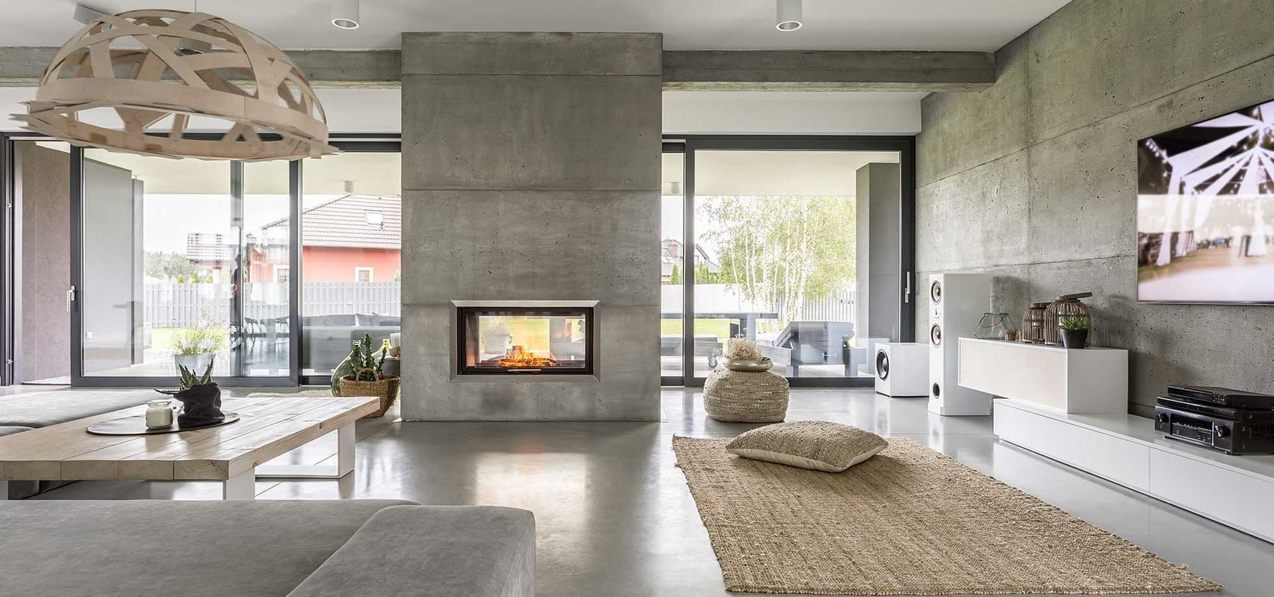 Open-plan living space with exposed concrete structural walls and beams