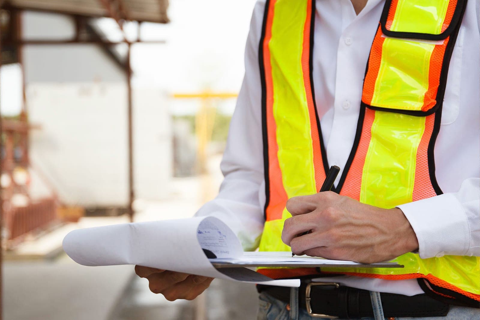 Engineer reviewing drawings during a site inspection